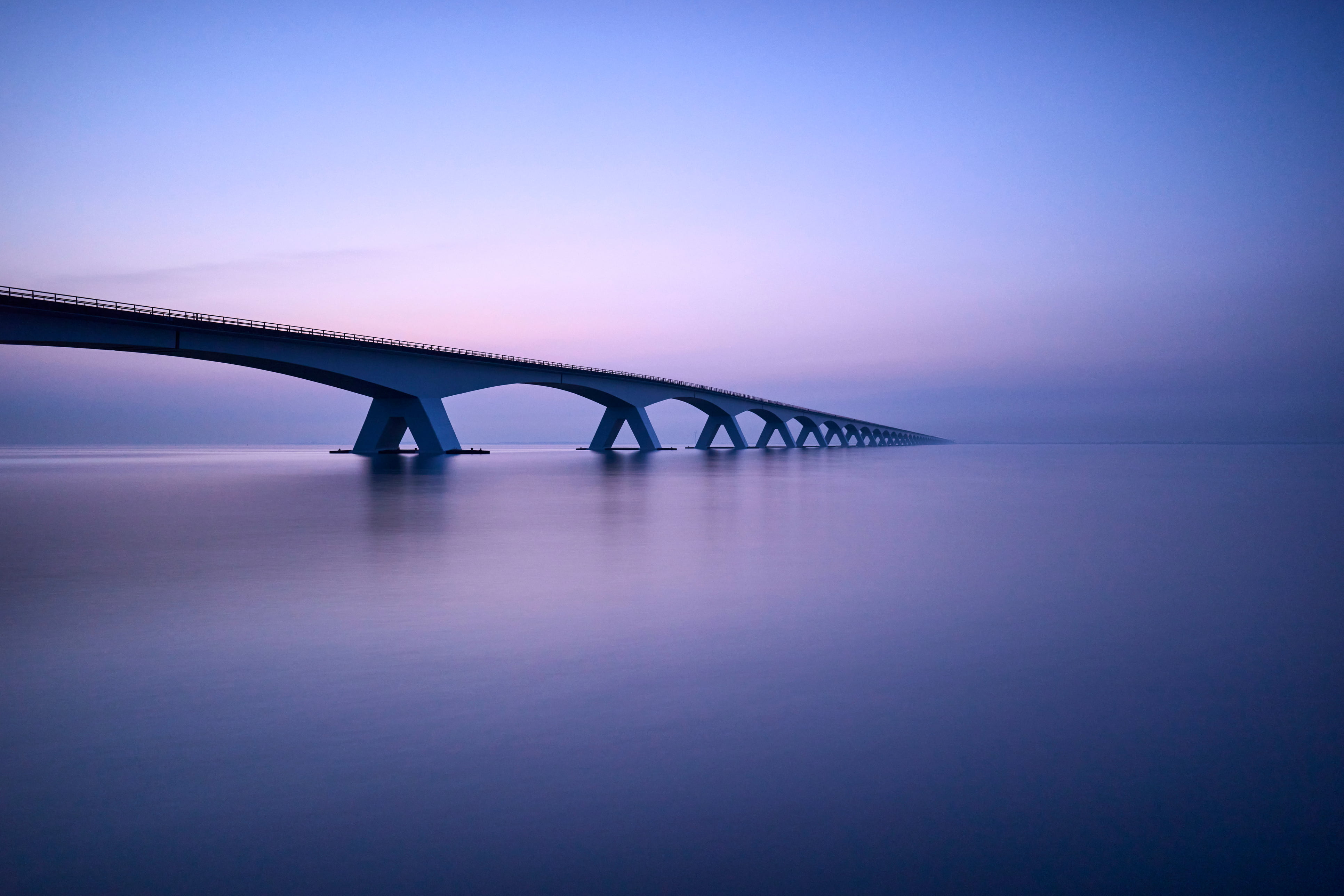Bridge over large body of water at dusk