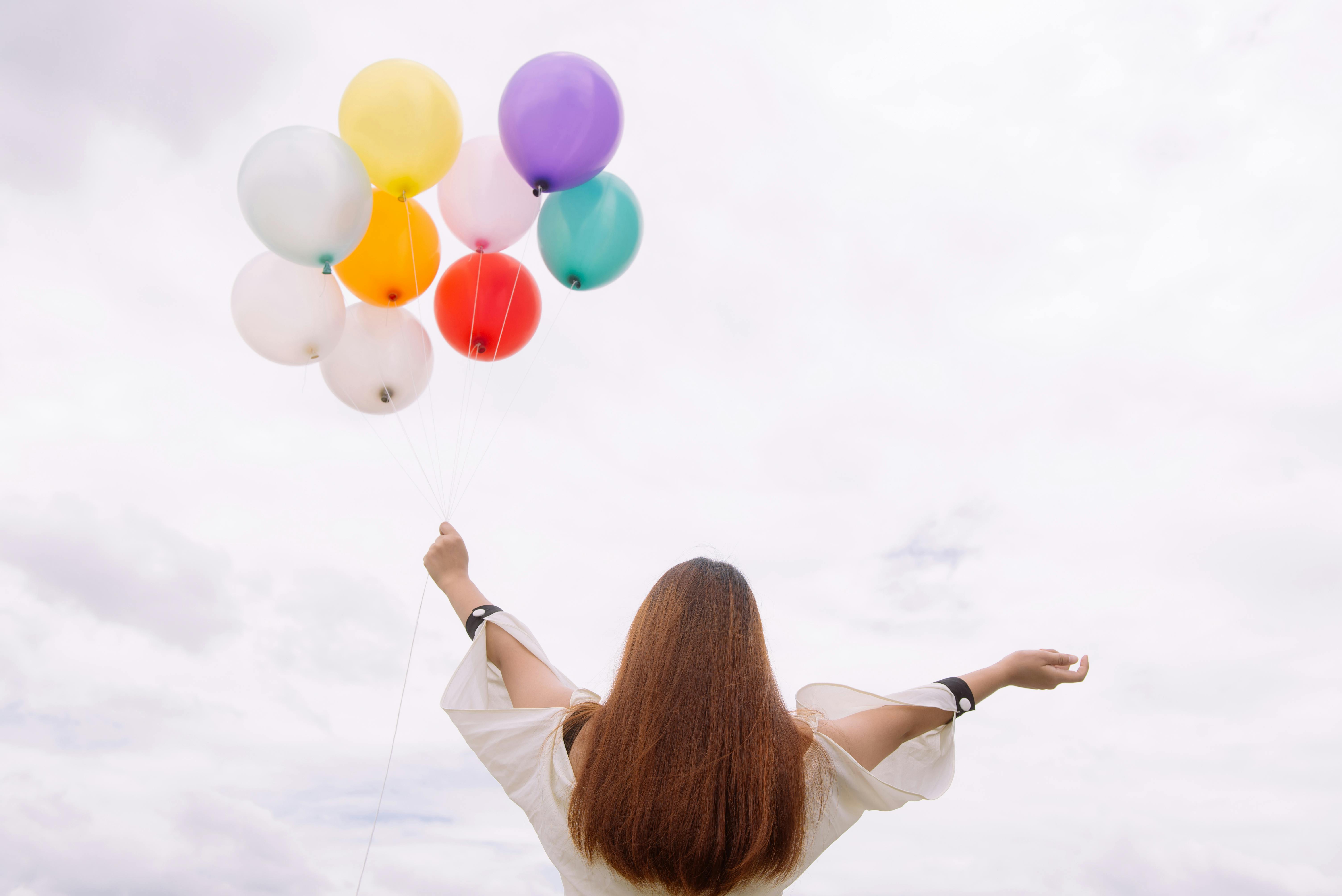 https://www.pexels.com/photo/worm-s-eye-view-of-woman-holding-balloons-887824/ Photo by Tirachard Kumtanom: 