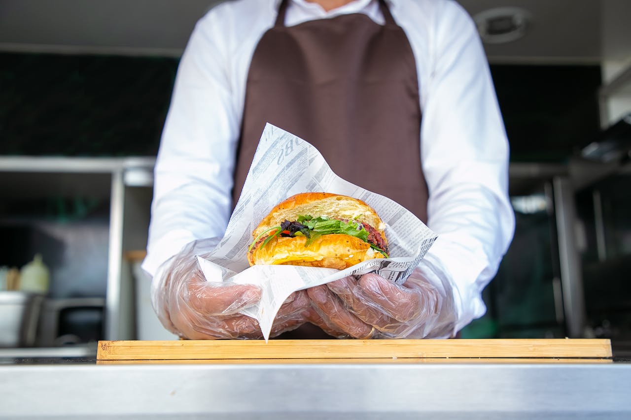 Photo by Kampus Production: https://www.pexels.com/photo/cook-standing-in-food-truck-and-giving-burger-5920741/ 