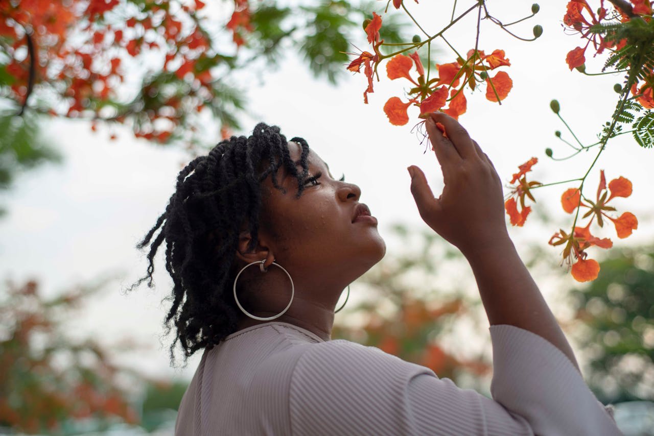 https://www.pexels.com/photo/a-woman-is-looking-at-flowers-in-a-tree-20336076/  Photo by David Kwewum on Pexels 