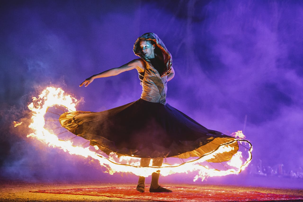 Photo by Vadim Braydov: https://www.pexels.com/photo/a-woman-wearing-a-dress-with-fire-12221697/