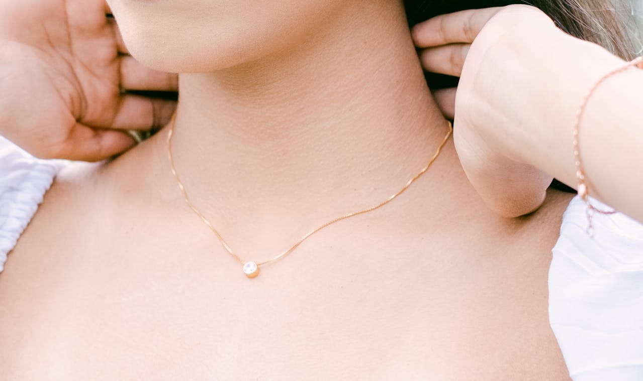Photo by Arjun  Adinata: https://www.pexels.com/photo/a-person-wearing-a-gold-necklace-with-pendant-15157998/ 