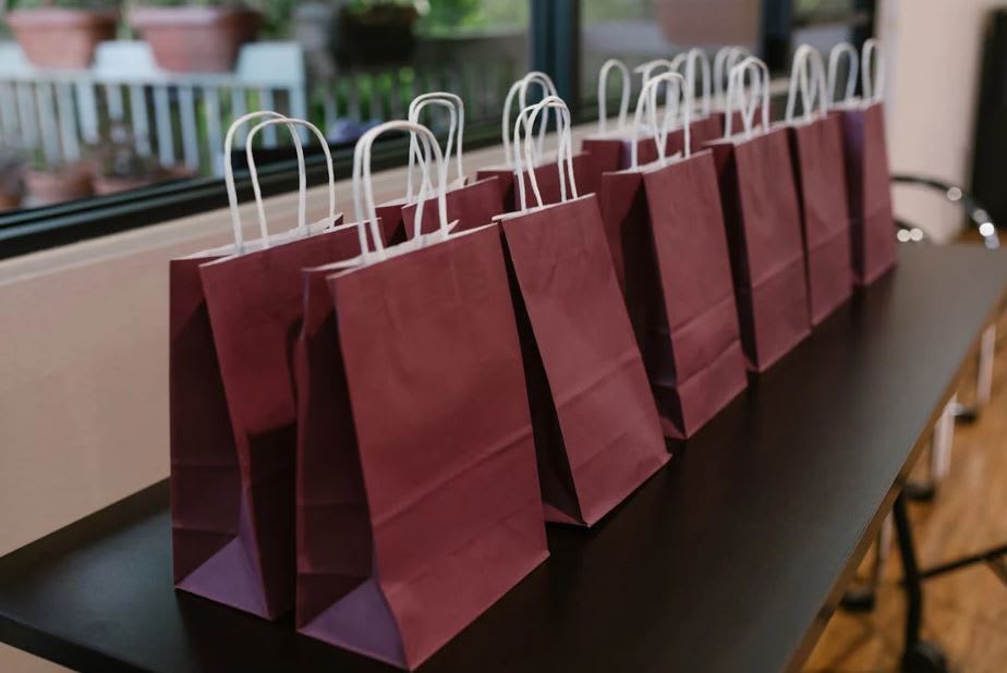 Photo by RDNE Stock project: https://www.pexels.com/photo/close-up-shot-of-maroon-paper-bags-on-a-table-7648227/ 