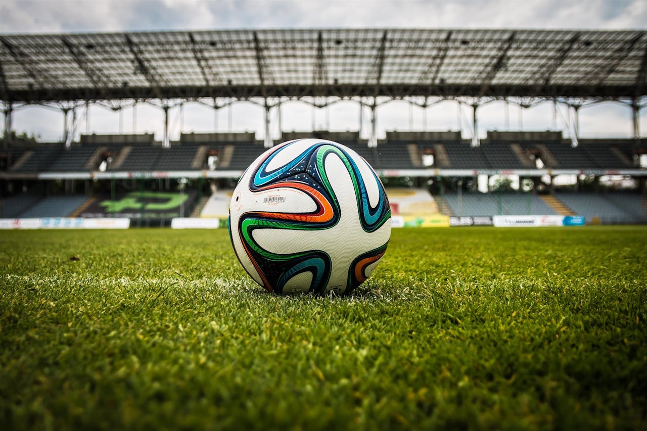 https://www.pexels.com/photo/multicolored-soccer-ball-on-green-field-47730/ Photo by Pixabay on Pexels