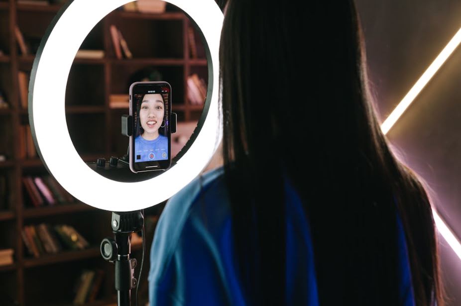 https://www.pexels.com/photo/a-woman-recording-herself-with-a-smartphone-7676401/ 