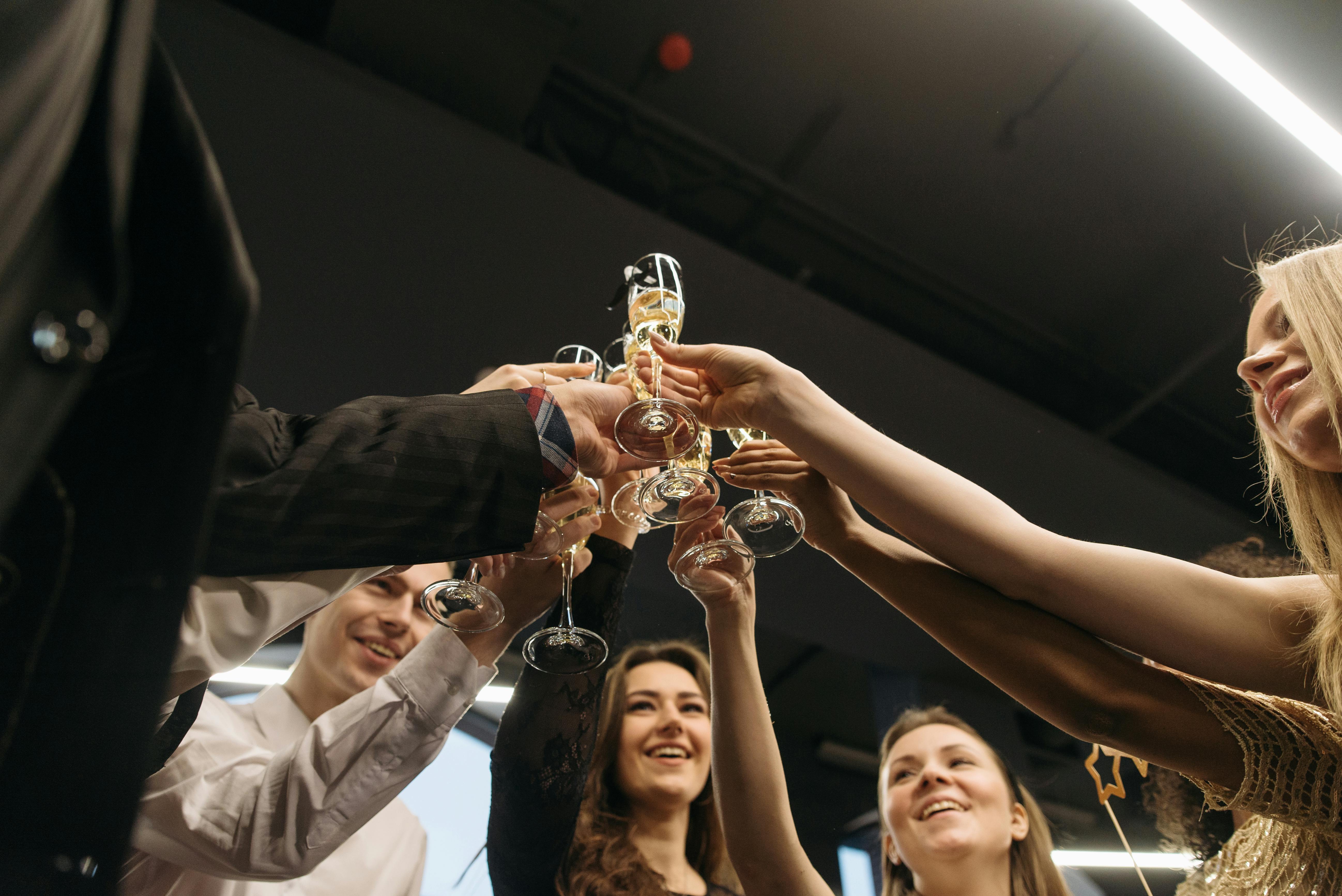 https://www.pexels.com/photo/a-group-of-people-toasting-their-drinks-6405666/