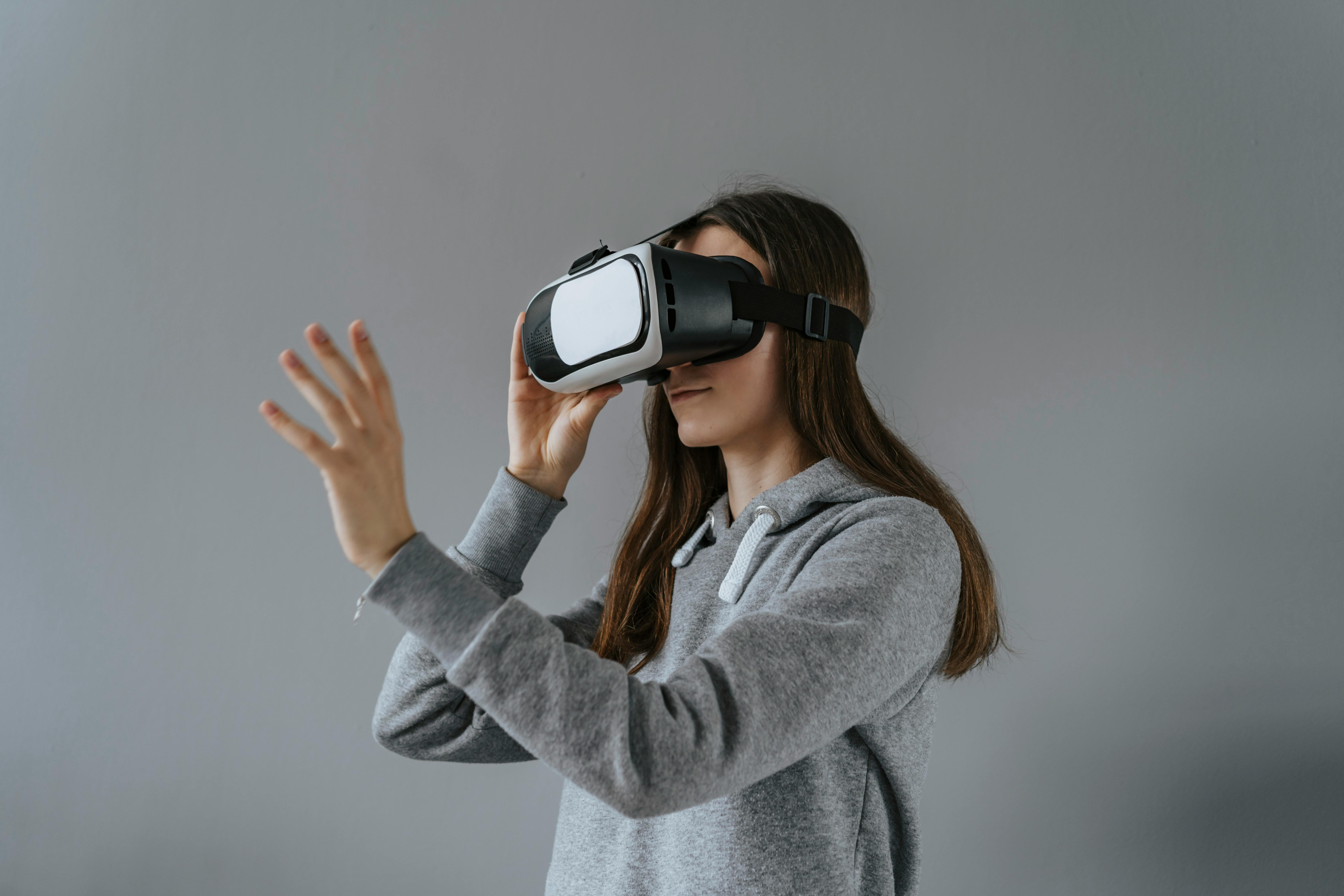 https://www.pexels.com/photo/a-woman-in-gray-hoodie-standing-near-gray-wall-while-wearing-virtual-reality-glasses-5309576/