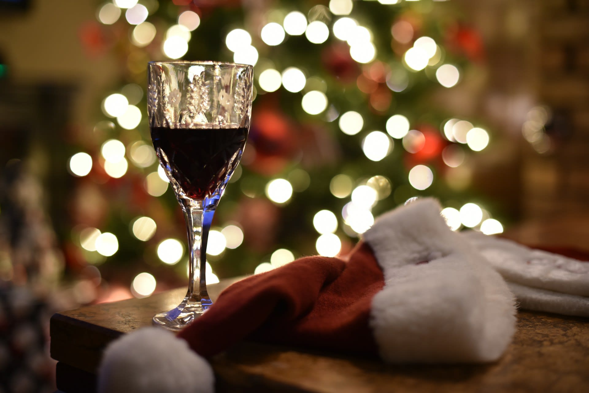 https://unsplash.com/photos/a-glass-of-wine-and-a-santa-hat-on-a-table-OSNpxqv-38s Photo by SANDY HIBBARD on Unsplash