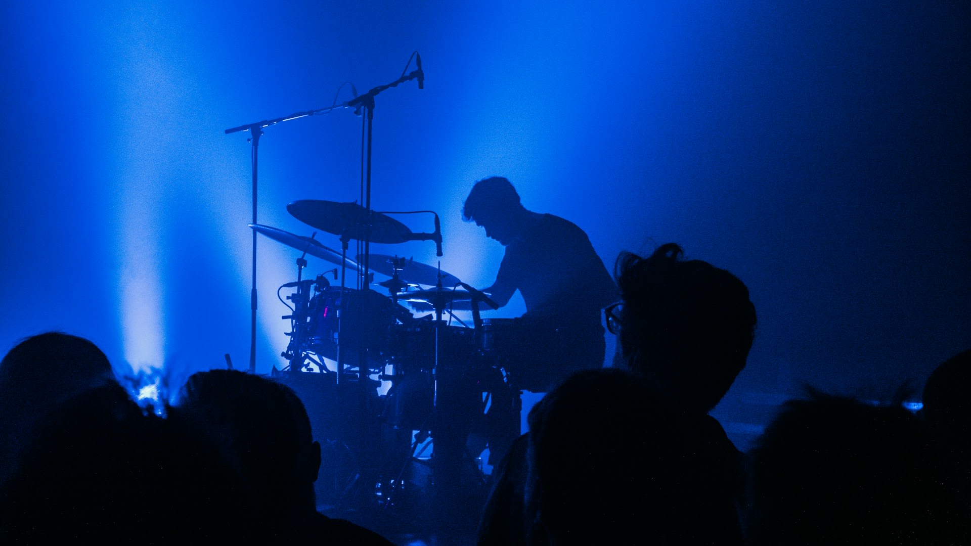 https://unsplash.com/photos/a-man-playing-drums-in-front-of-a-crowd-of-people-hz9ZqP-ut2g, Photo by Samuel Regan-Asante on Unsplash