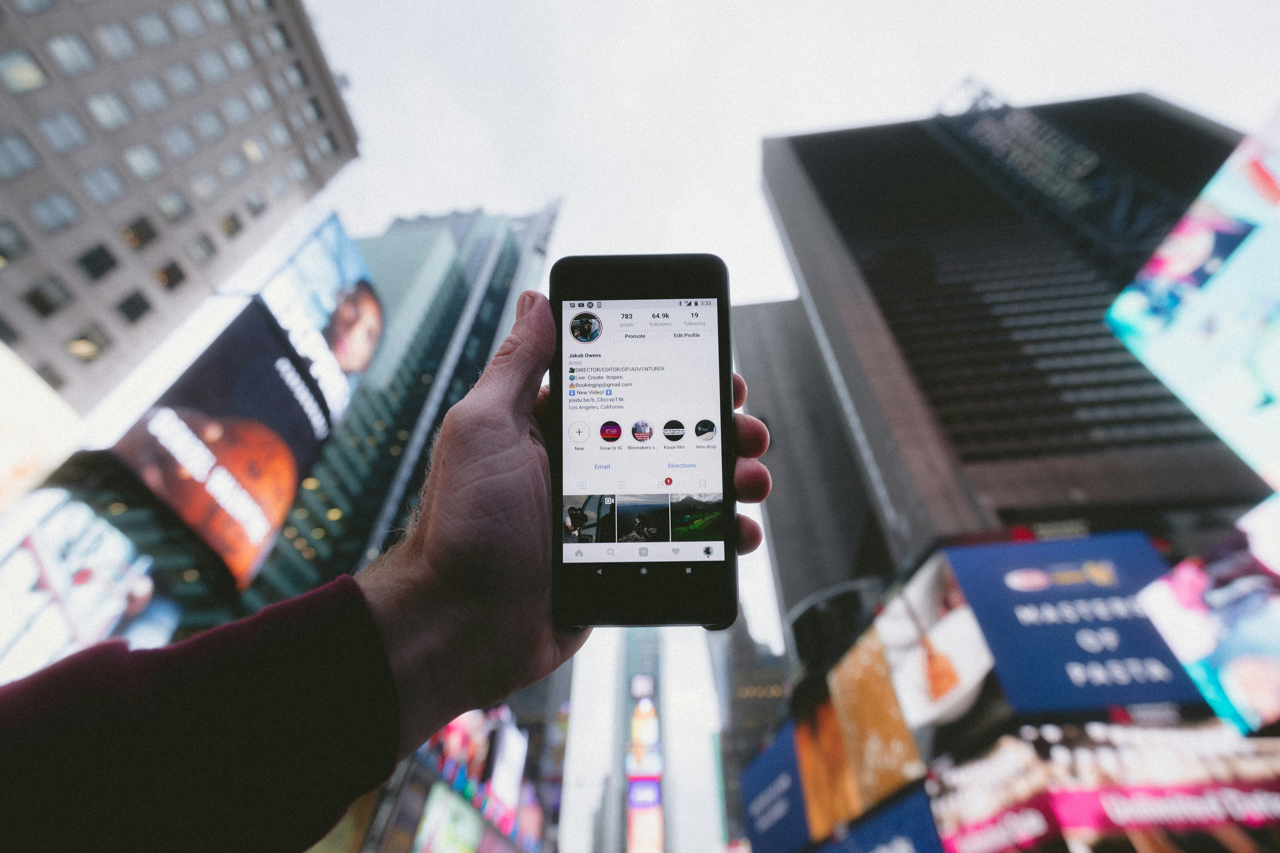 https://unsplash.com/photos/high-angle-photo-of-person-holding-turned-on-smartphone-with-tall-buildings-background-WUmb_eBrpjs