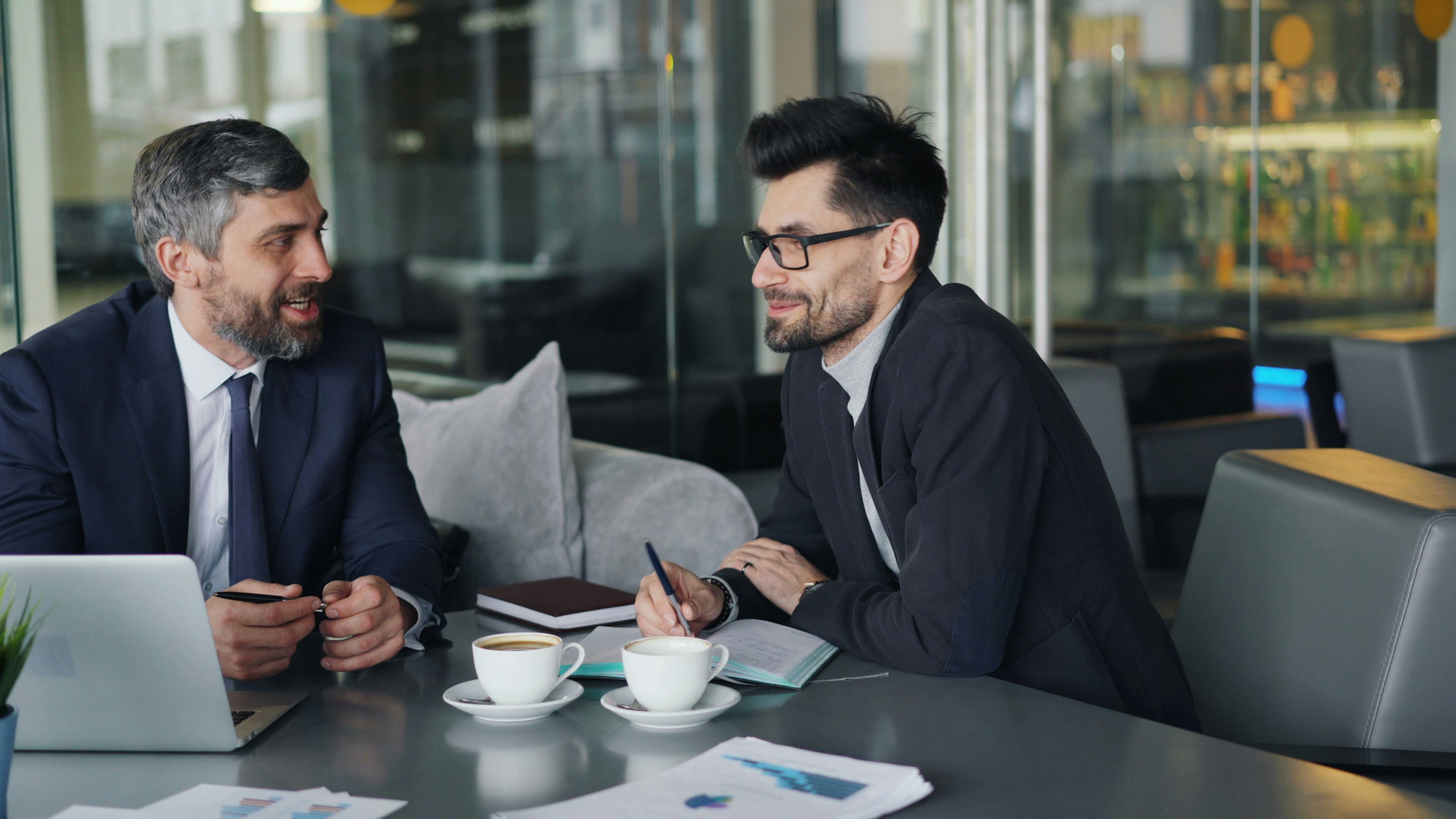 https://unsplash.com/photos/a-couple-of-men-sitting-at-a-table-in-front-of-a-laptop-0e5EGrNj-ss