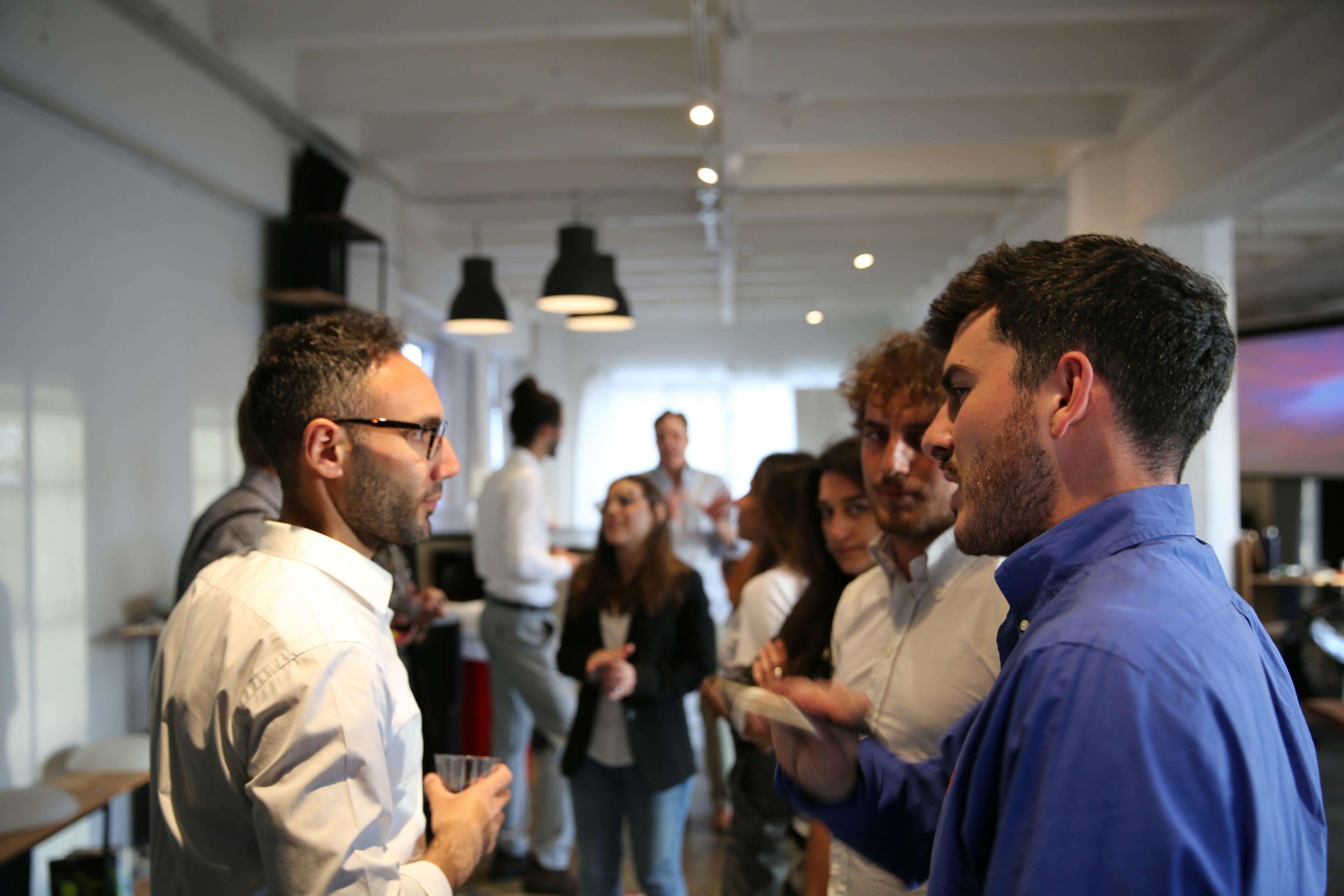 https://unsplash.com/photos/a-group-of-people-standing-in-a-room-yTsy3PYFPtc