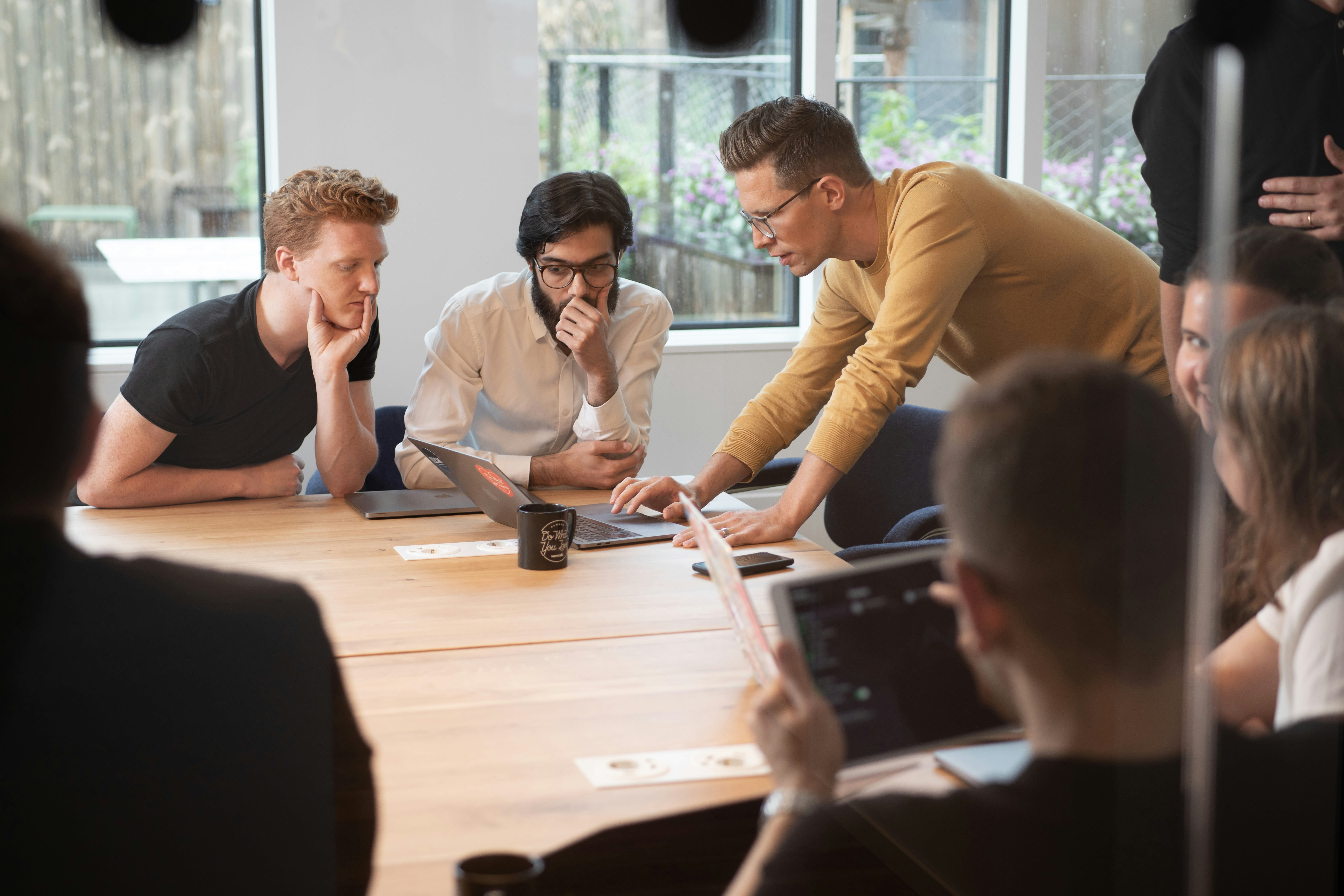 https://unsplash.com/photos/a-group-of-people-sitting-around-a-wooden-table-OLXBoNfb8kA