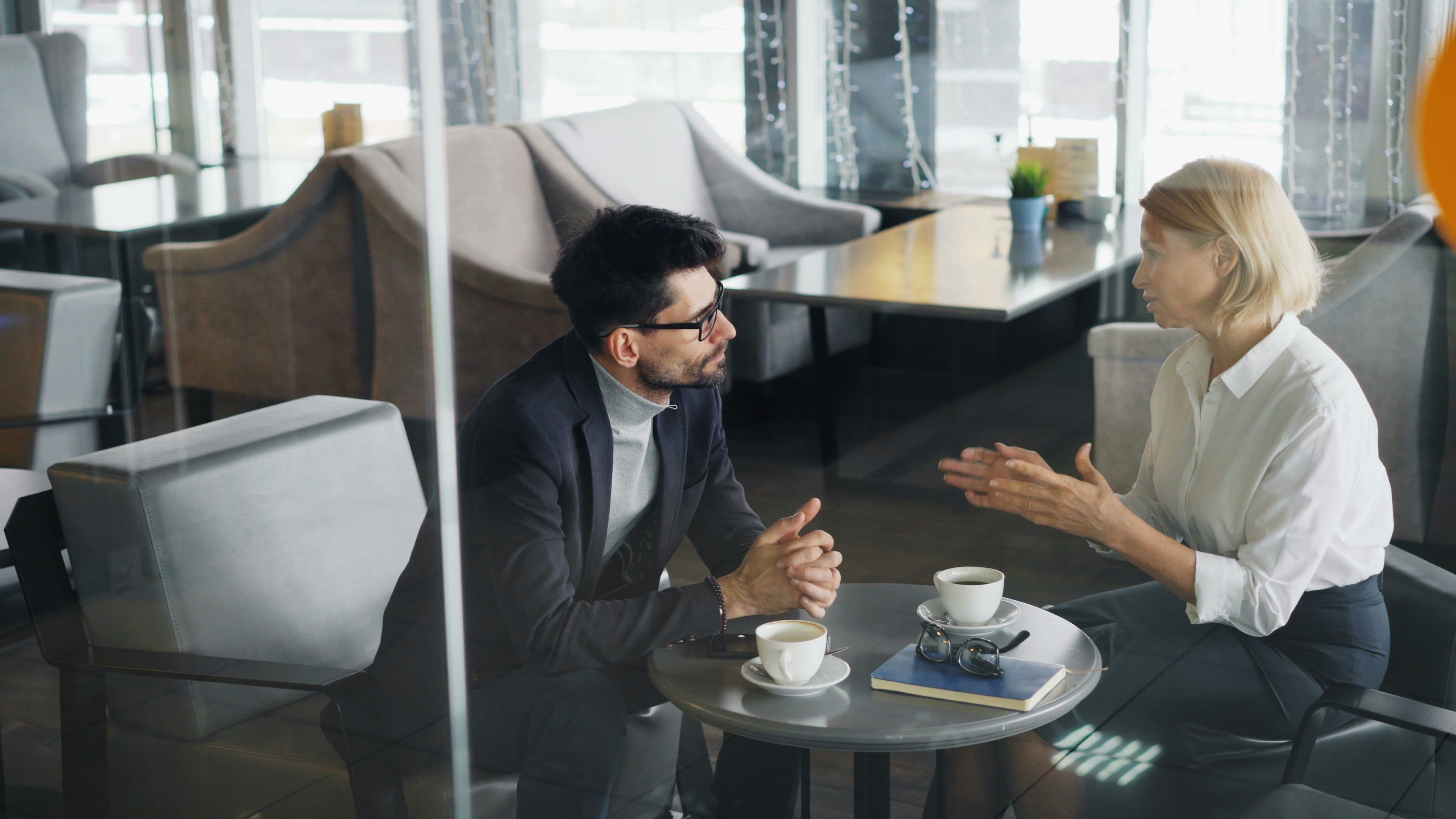https://unsplash.com/photos/a-man-and-a-woman-sitting-at-a-table-talking-xxOZppN-fik