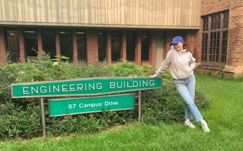 An image of a young woman smiling in front of the Engineering Building. at the University of Saskatchewan.