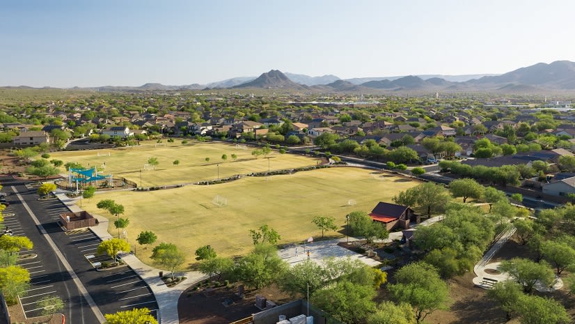Green, flat suburban landscape with trees and grassy fields, mountains in the background in Arizona, New Mexico and Texas.