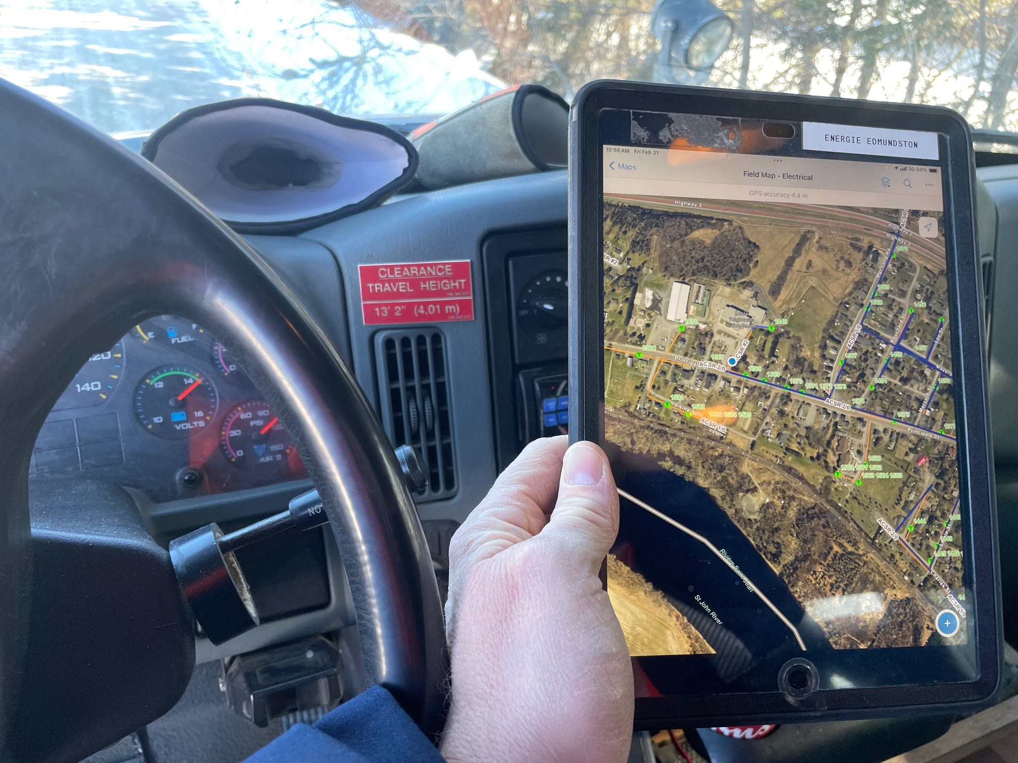 Field worker point of view sitting in the driver’s seat of a public works vehicle holding a tablet with an ArcGIS map. 