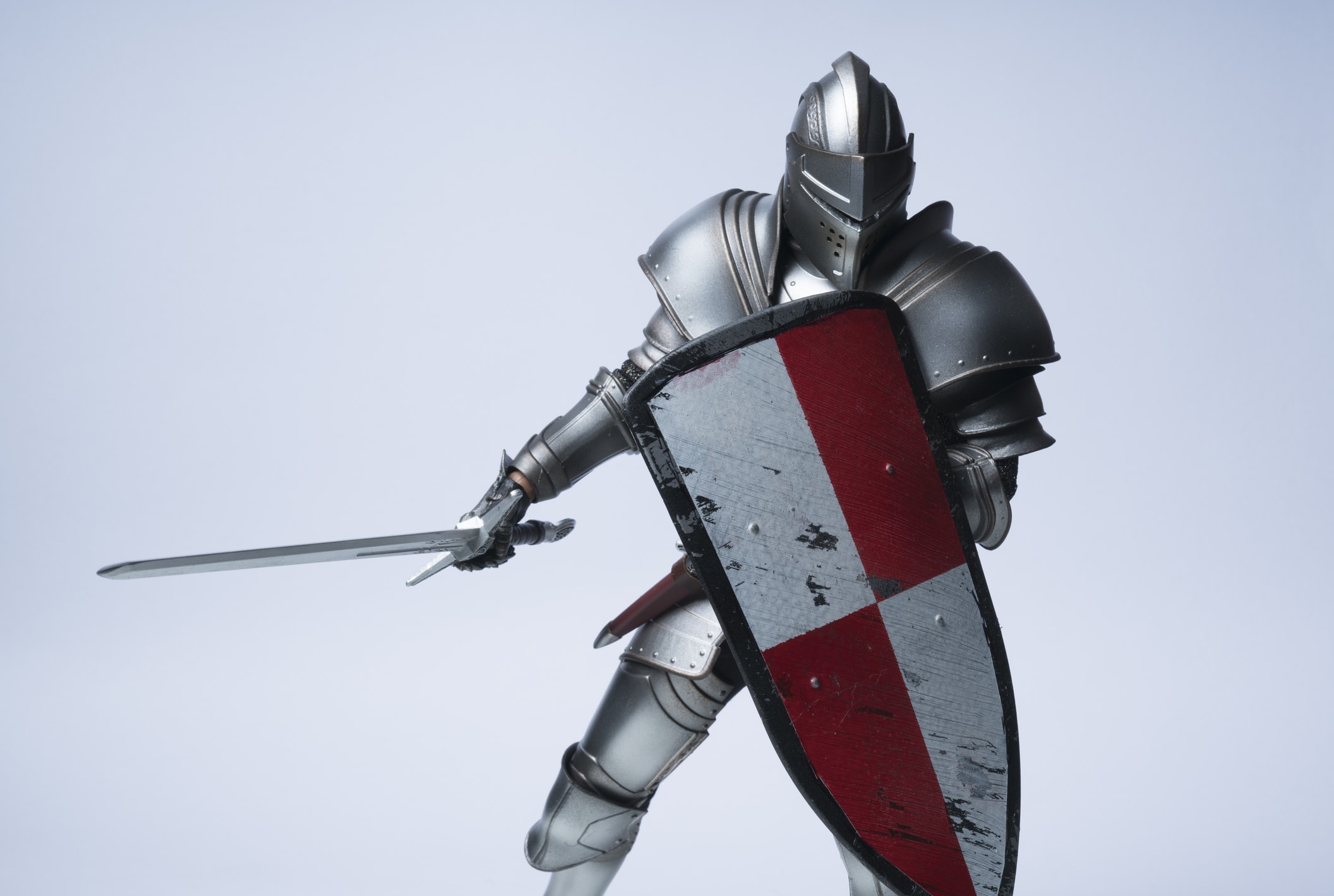 An armoured knight holds a shield and sword in a ready posture.