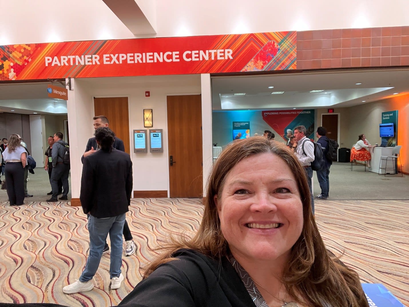 Esri Canada partner manager Fiona Hatfield stands in front of the Partner Experience Centre, a brightly-lit, custom-built space for partners to connect with Esri and its distributors at the 2025 Esri Partner Conference.
