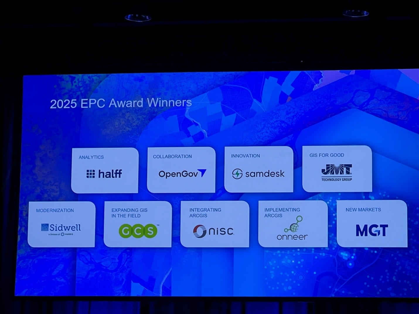 A slide displayed on a projector screen titled “2025 EPC Award Winners”. The winners listed include Halff, OpenGov, samdesk, JMT, Sidwell, GCS, NISC, Onneer and MGT.