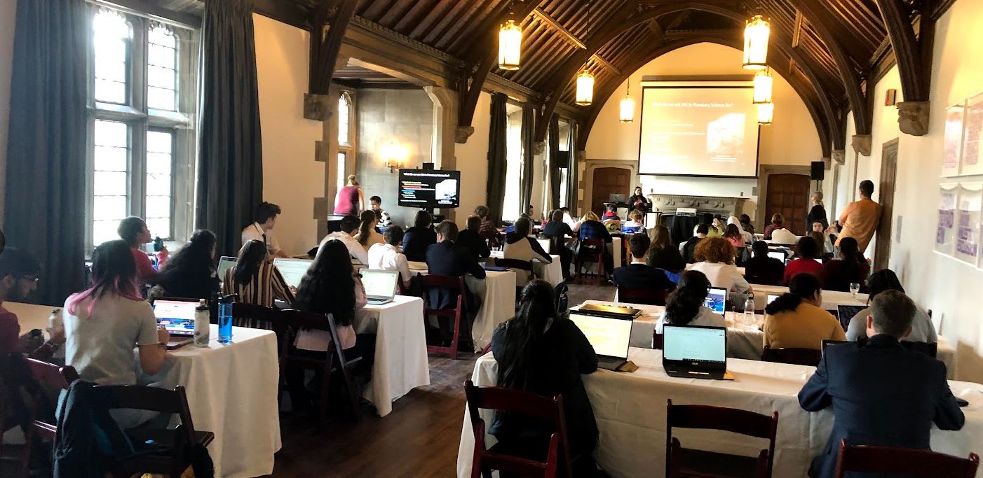 Des personnes utilisant leurs ordinateurs portables lors d’une séance de conférence dans une grande salle du Hart House.