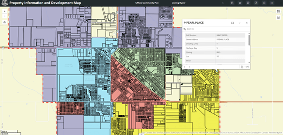 A screenshot of a mapping app with the City of Steinbach logo, the title “Property Information and Development Map” at the top navigation bar. The map shows sections of parcels in lavender, blue, pink, green and yellow. A grey popup box shows property information for 9 Pearl Place such as assessment roll number and zoning.