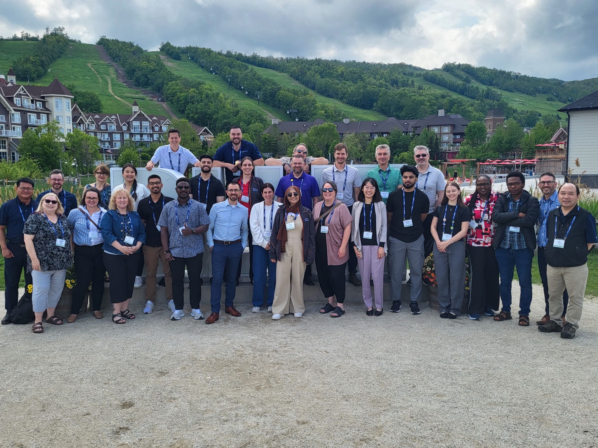 Group of individuals who are part of Esri Canada’s Public Works team in front of a sign and mountain at Blue Mountain, Ontario in June 2025.