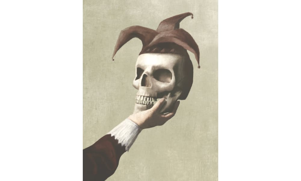 Against a light-coloured backdrop, a light-skinned human hand holds a skull that is wearing a three-pointed jester’s hat.