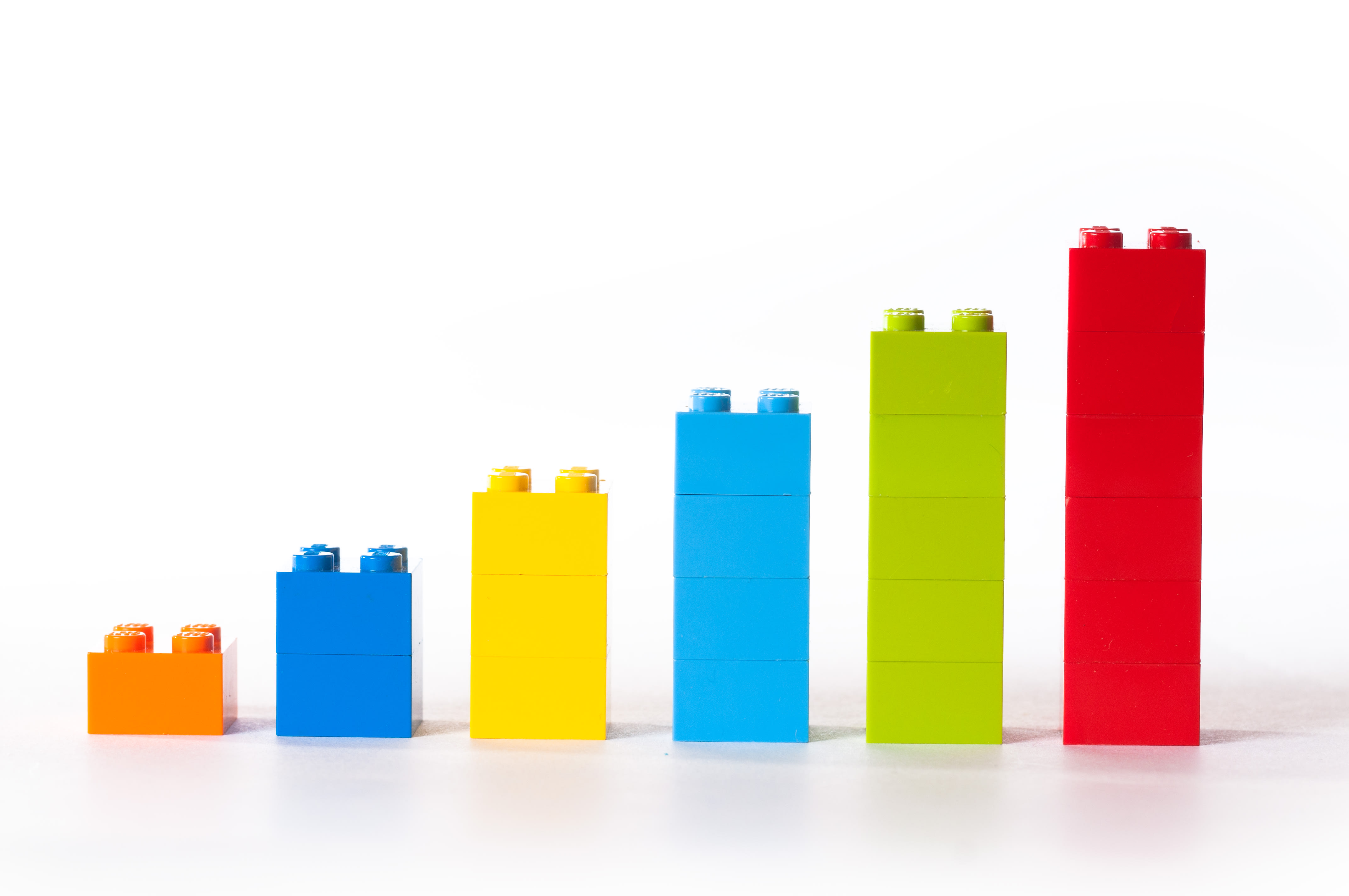 Six piles de briques LEGO de couleurs distinctes, classées de la plus petite (à gauche) à la plus grande (à droite).
