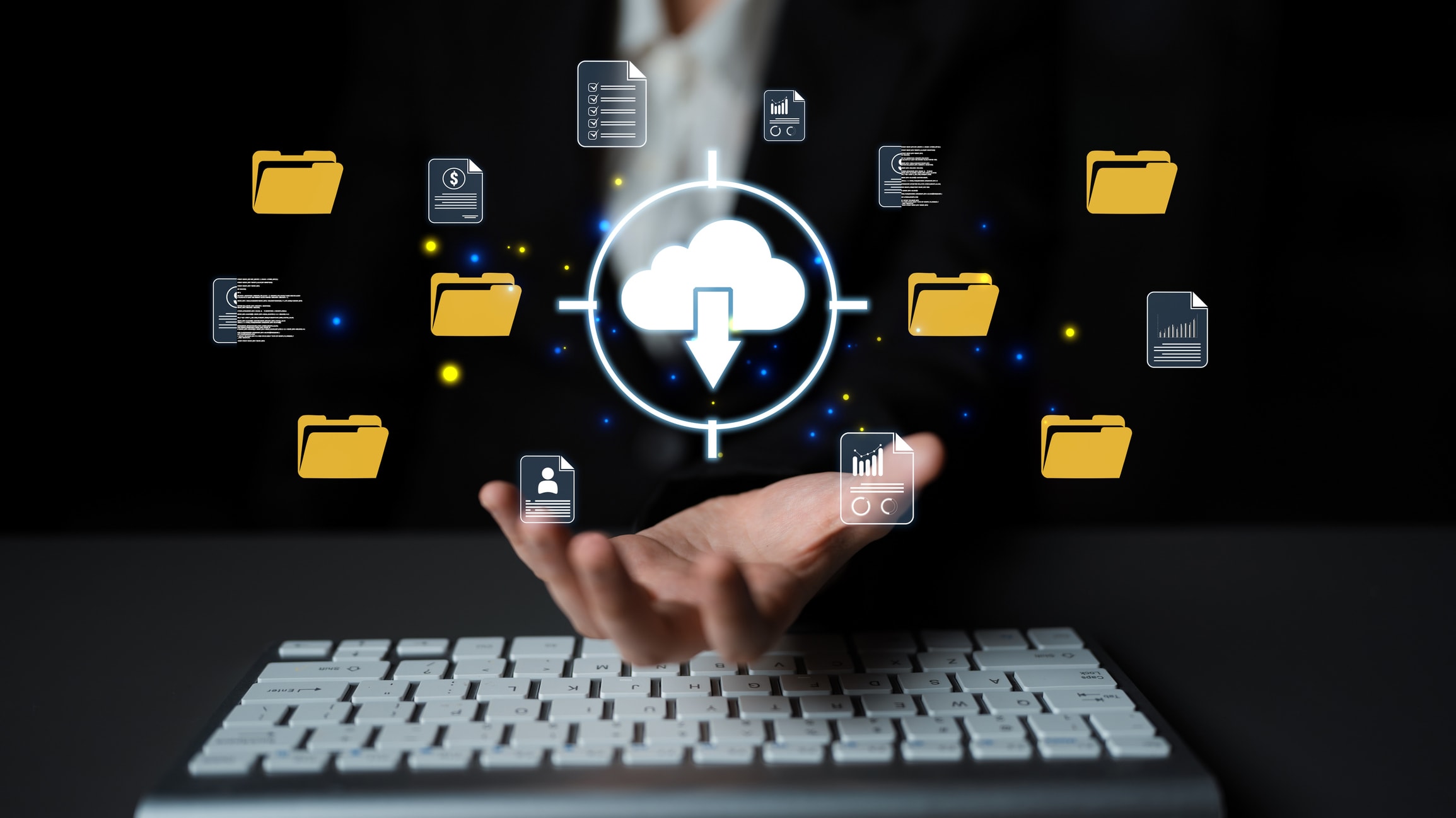 An image of an upward facing hand over a computer keyboard, with images hovering above of documents and folders all coming together into a cloud graphic with a downward pointing arrow to indicate one combined source.