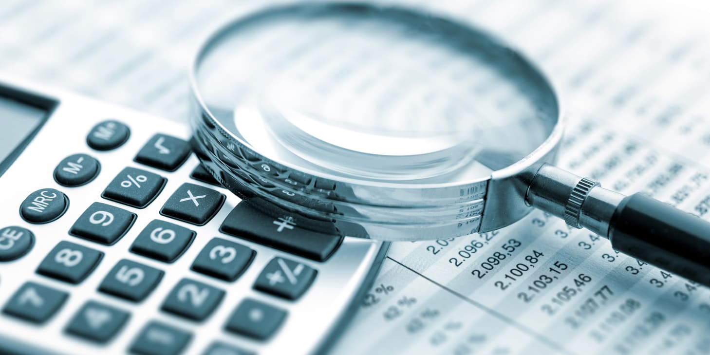 Calculator and magnifying glass sitting on top of paper listing HOA transfer fee balances.