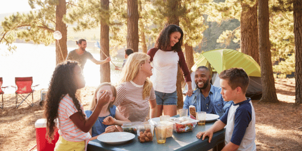 family eating food around campsite
