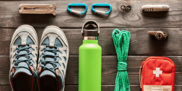 items for hiking, including first-aid kit, hiking boots, and water bottle