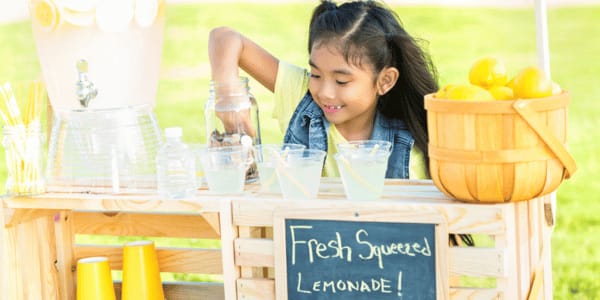 Little girl sells lemonade in her front yard stock photo