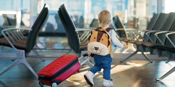 toddler rolling suitcase through airport