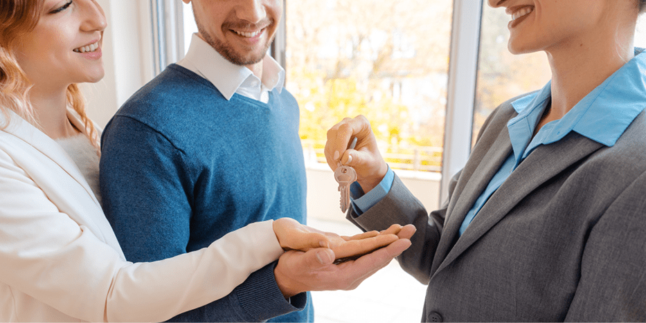 Landlord handing couple keys to a rental unit.