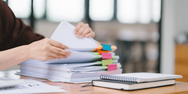 person sorting through stack of HOA governing documents