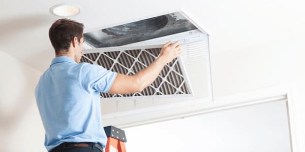 man changing air filter in HVAC