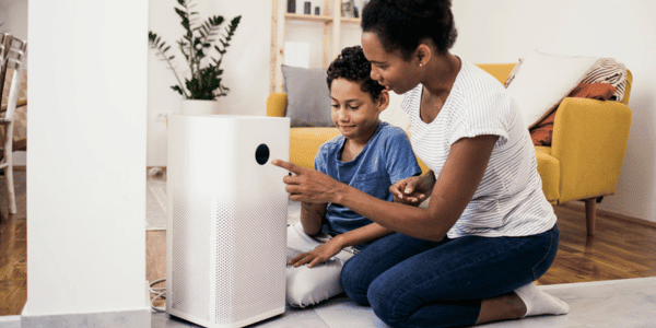 mother and son adjusting in-home air purifier