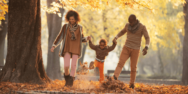 family playing in fall leaves