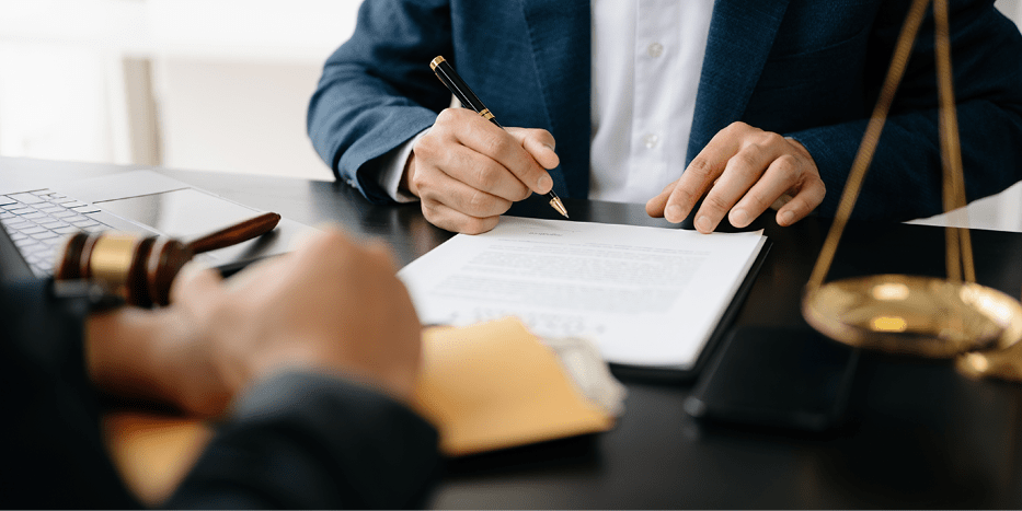 Man signing legal documents with attorney