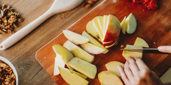 person chopping apples into apple slices
