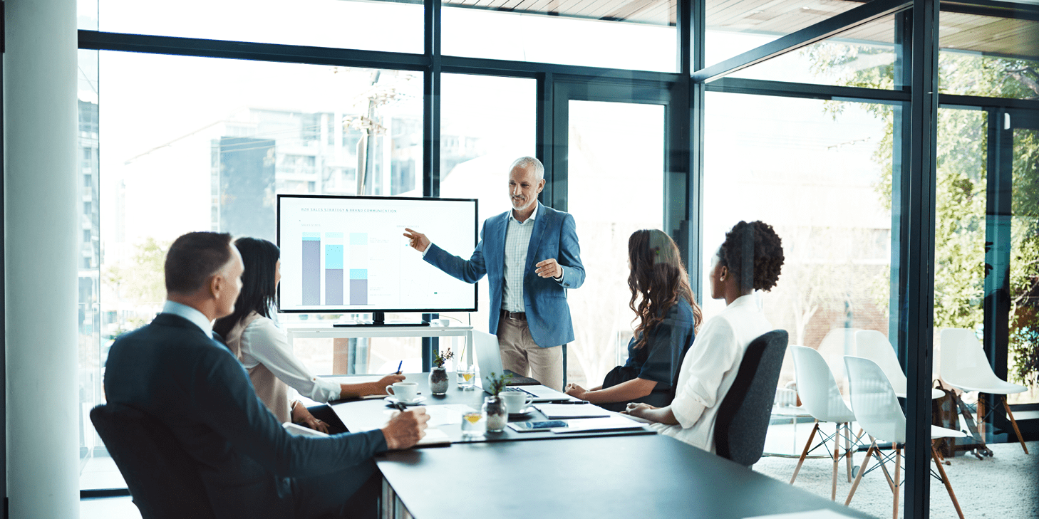 Man giving a presentation to three professionals in a meeting room