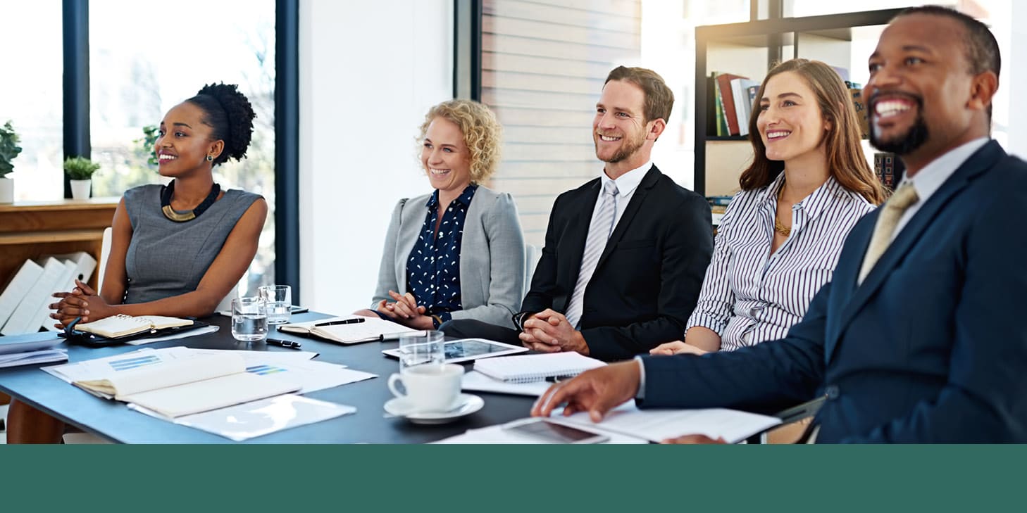 Smiling professionals sitting at a meeting table