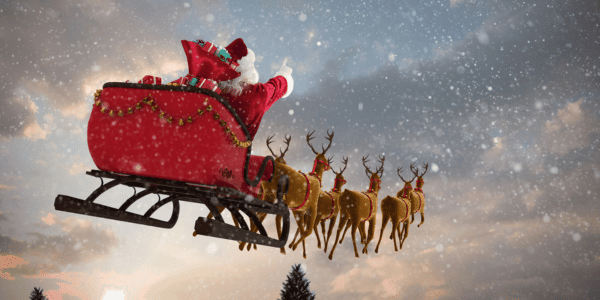 Santa flying in sleigh with reindeer