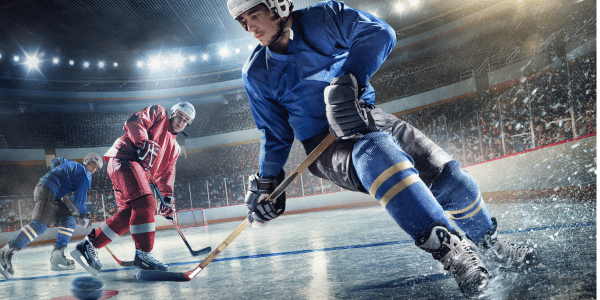 three ice hockey players playing ice hockey in packed arena