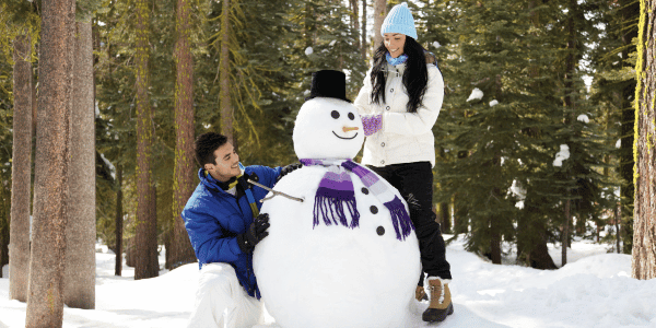 man and woman building snowman