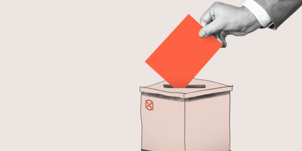 human hand putting ballot in ballot box for HOA election