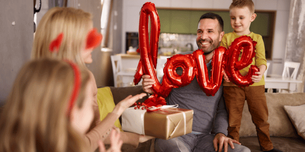 family celebrating valentines day with balloons and gifts
