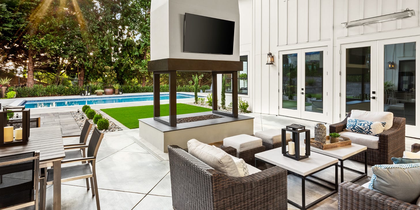 Deluxe patio area with chairs, tables, pool, firepit, and flat screen tv.